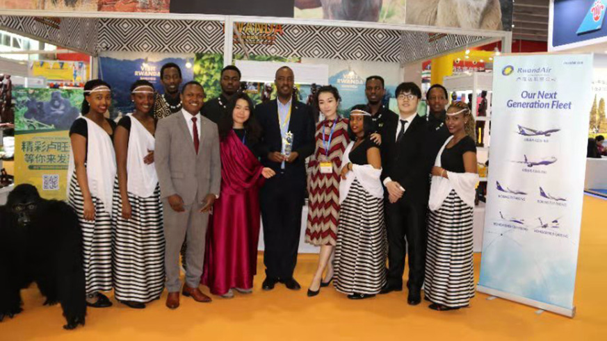 Amb. Charles kayonga (centre) poses with the award with Rwandan cultural dancers at the event. Courtesy.