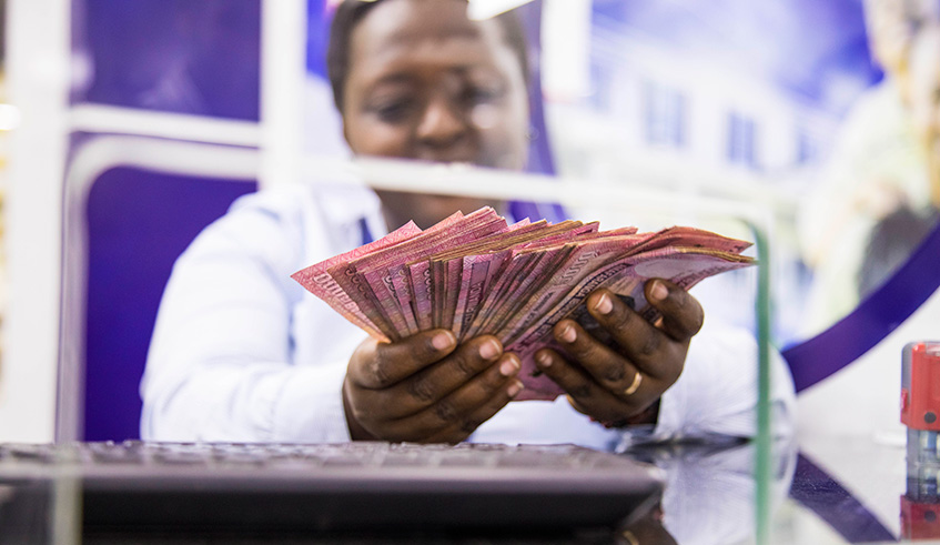 A teller counts money in one of the commercial banks in Kigali. Emmanuel Kwizera.