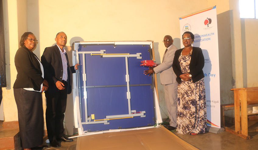 RTTF president Jean Bosco Birungi (2nd-L) hands over a brand new table tennis table to the administration of G.S Camp Kigali in Nyarugenge District during Mondayu2019s Commonwealth Day 2019 event. Jejje Muhinde.