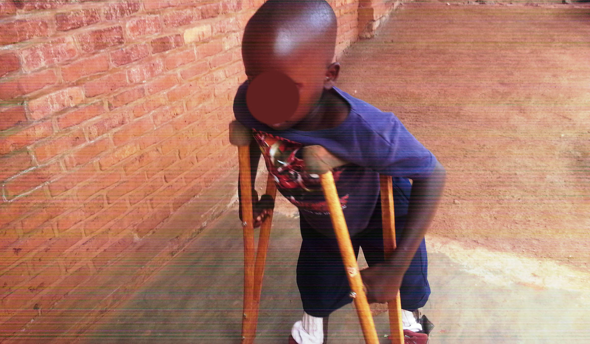 Aimu00e9 Irimaso walking on a pathway reserved for children with disabilities at G.S Bumbogo.  Marie Anne Dushimimana.