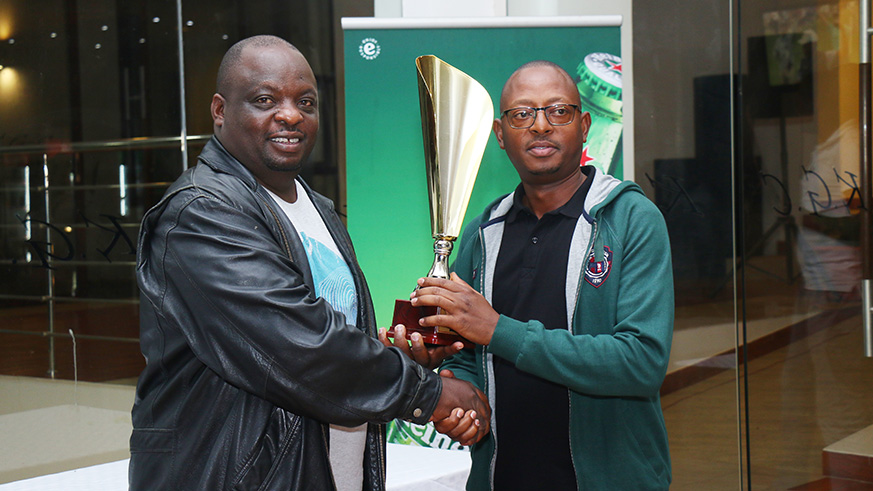 Kigali Golf Club captain, Davis Kashaka (L) hands the trophy to Gentil Kangaho as the overall winner of the multi-category competition. Jejje Muhinde.