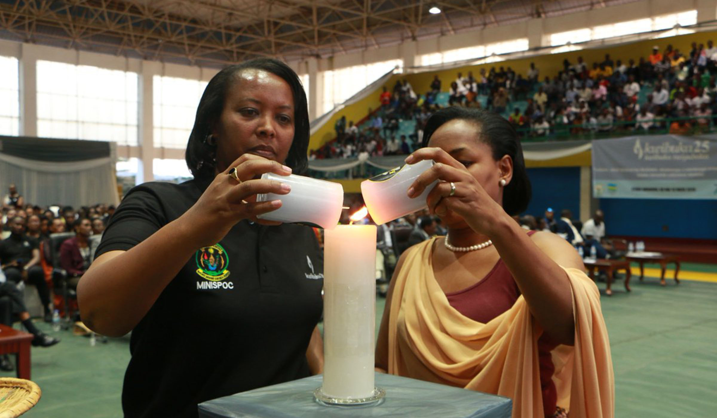 Sports minister Esperance Nyirasafari (L), and Youth minister Rosemary Mbabazi light the light of remembrance during the event at Petit Stadium on Wednesday. Courtesy.