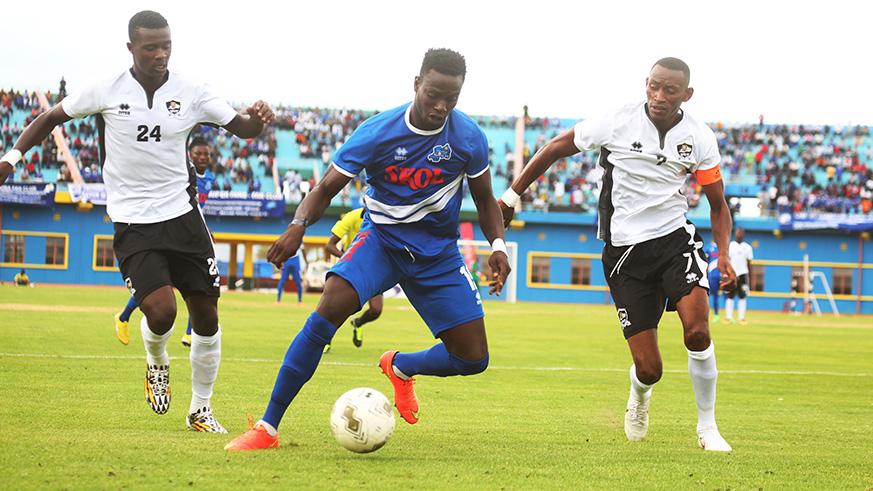 Rayon Sports u2018hero of the dayu2019 Michael Sarpongo dribbles past APR skipper Jean Baptiste Mugiraneza (R) and Emmanuel Imanishimwe (L) during the 1-0 victory at Amahoro National Stadium on Saturday. Sam Ngendahimana.