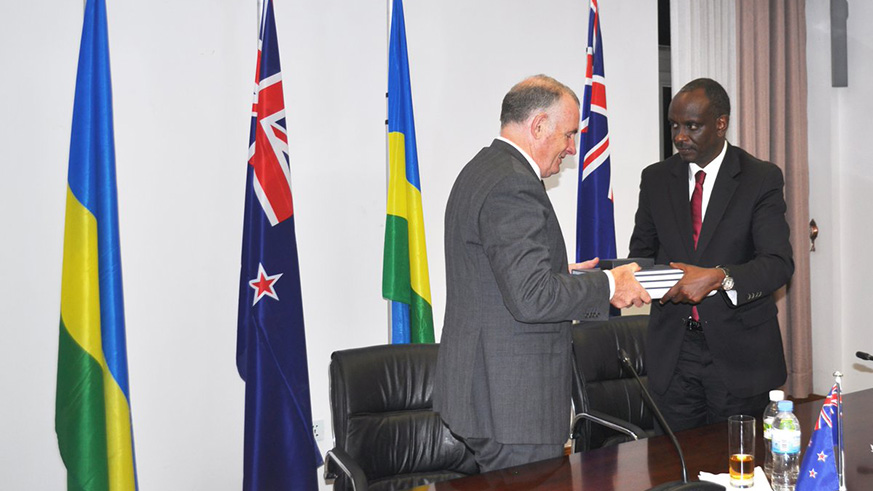 Speaker Mallard (L) hands over to Minister Sezibera physical copies of the archives related to the 1994 Genocide against the Tutsi. Courtesy.
