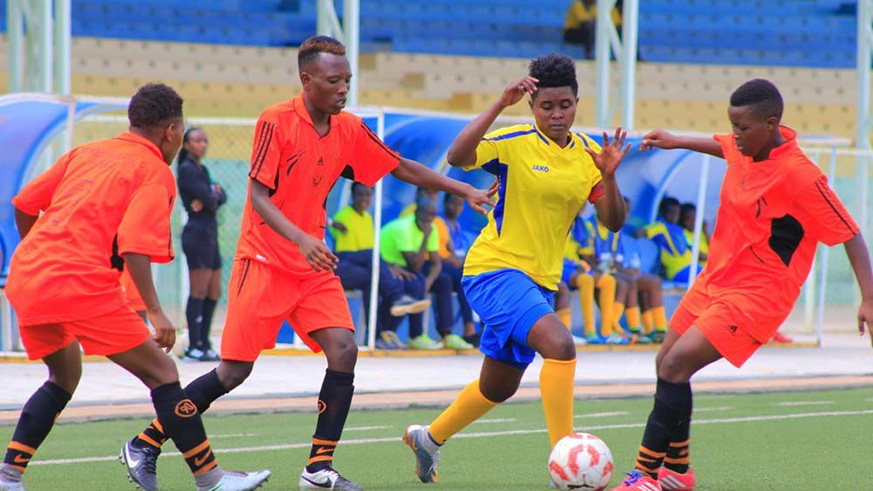 AS Kigali skipper Alice Kalimba (with the ball) tries to dribble through three Scandinavia players during a past match between the two sides at Kigali Stadium. File.