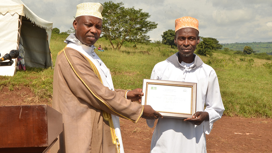 Mufti Hitimana, hands a certificate  to Bagabo, who led the resistance against Genocide perpetrators in Mabare.Courtesy.