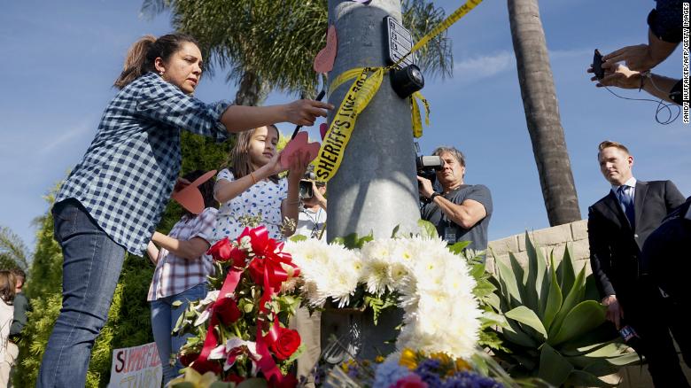 A woman and a young girl place notes across the street from the Chabad of Poway Synagogue after the shooting. / Internet photo