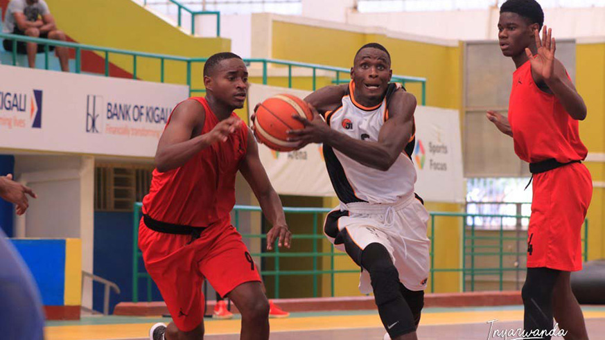 Pascal Niyonkuru charges through two Rusizi BBC players for the basket during the 139-58 victory at Amahoro Stadium on Sunday. Courtesy.