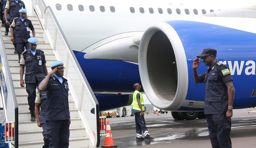 CP John Bosco Kabera (right) salutes the replaced contingent headed by ACP Emmanuel Karasi as they disembark from RwandAir at Kigali International Airport. Courtesy photos.