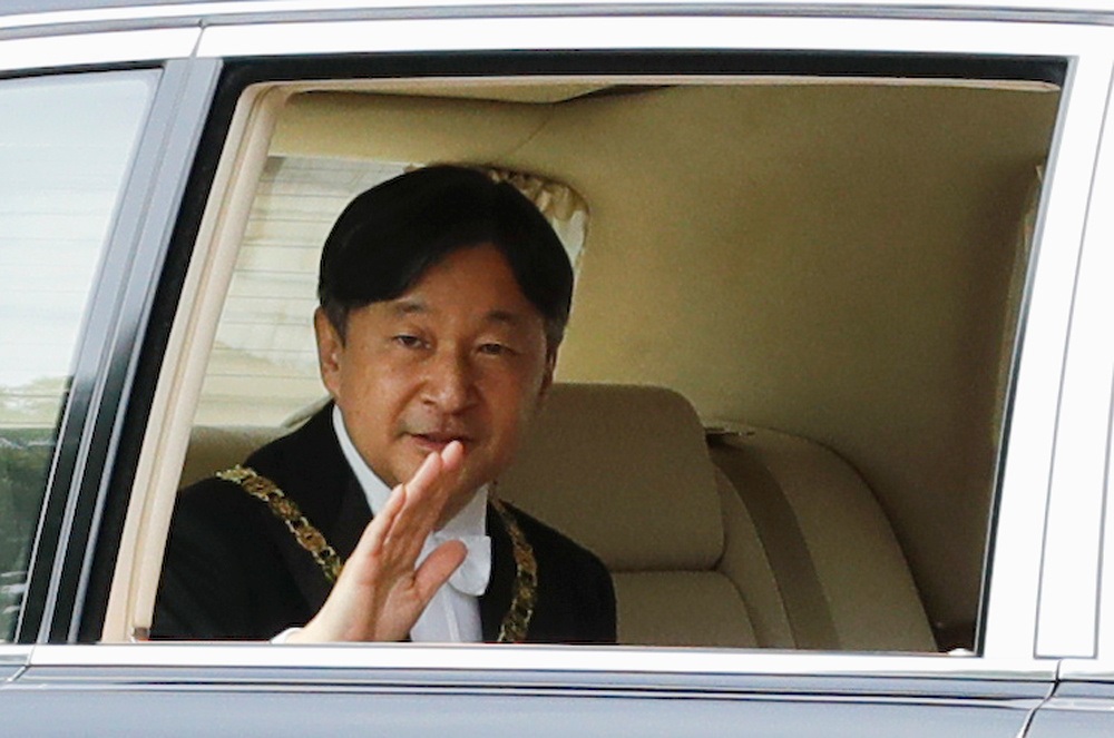 Japan's Emperor Naruhito waves from his vehicle upon arriving at the Imperial Palace in Tokyo. / Internet photo