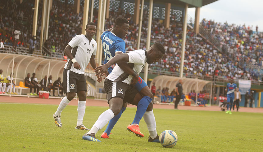 Ghanaian striker Michael Sarpong (in blue), seen here in a challenge with APR centre-back Herve Rugwiro, has scored 13 goals for Rayon Sports this season. Sam Ngendahimana