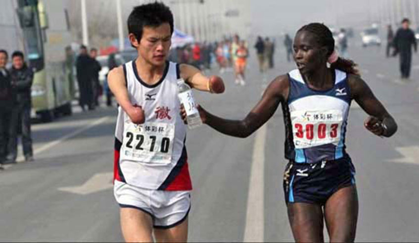 A world-class marathon runner slows down to help a disabled man drink water. Net photo.