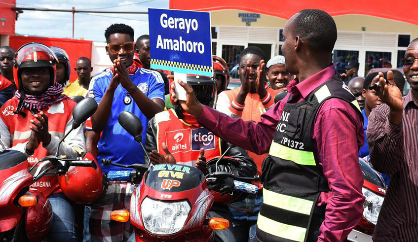 Motorcycle taxi operators applaud an official during the launch of road safety campaign. Courtesy.