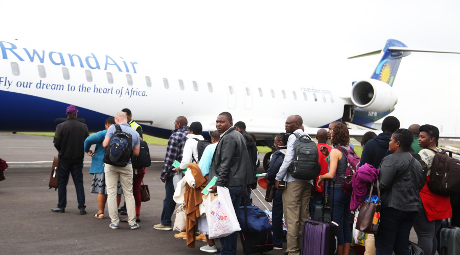 Passengers queue to board a RwandAir plane during the launch of Kigali-Cape Town route recently. Experts have called on African countries to emulate Rwanda by embracing a visa-free policy. / Sam Ngendahimana