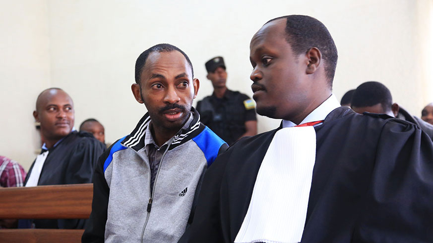 Nsabimana (left) consults his lawyer Moise Nkundabarashi in court on Thursday. File.