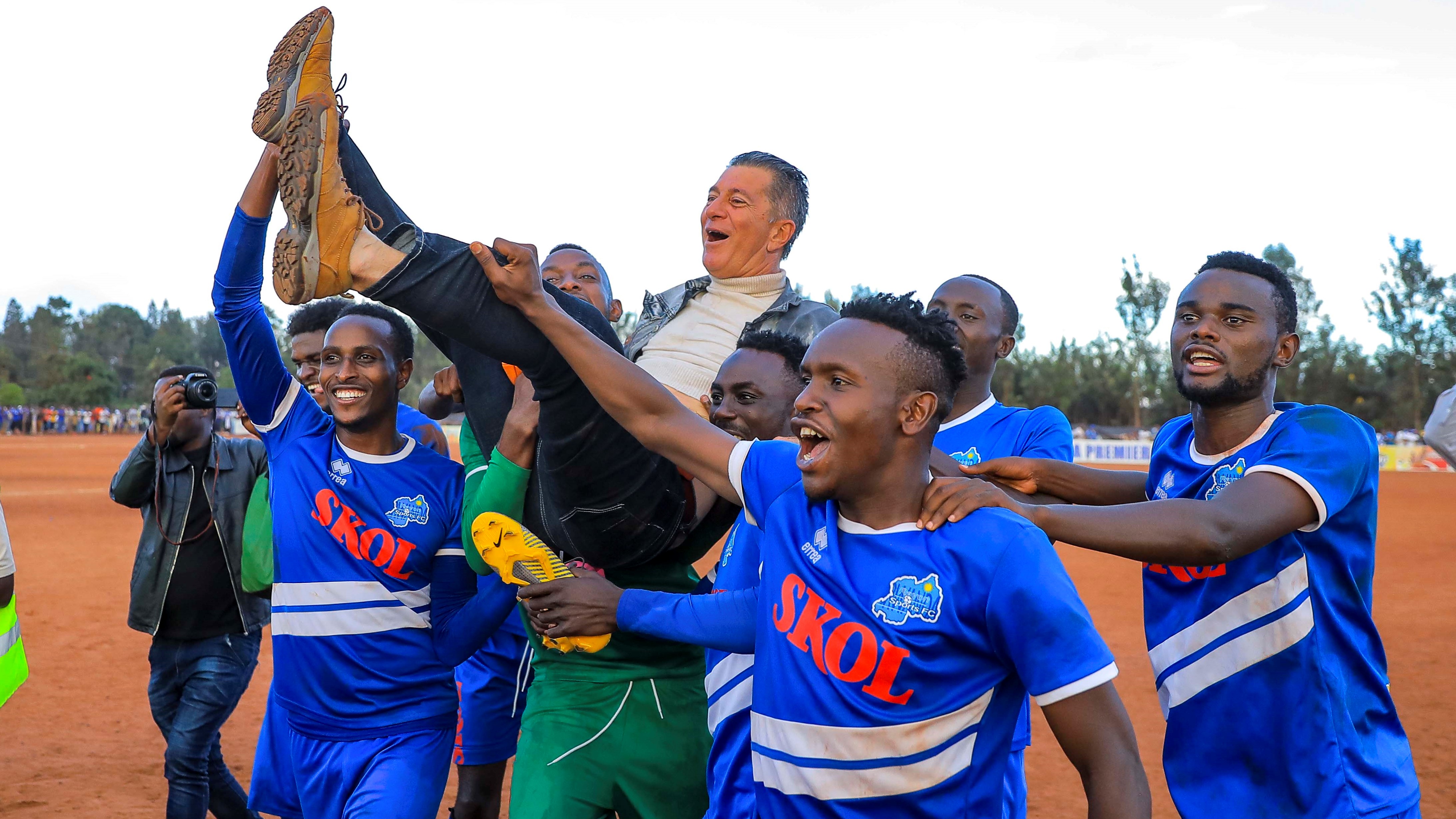 Rayon Sports players lift Brazilian manager Roberto Oliviera aloft after thumping Kirehe 4-0 to claim the 2018-19 Azam Rwanda Premier League title at Nyakarambi stadium on Friday. Courtesy.