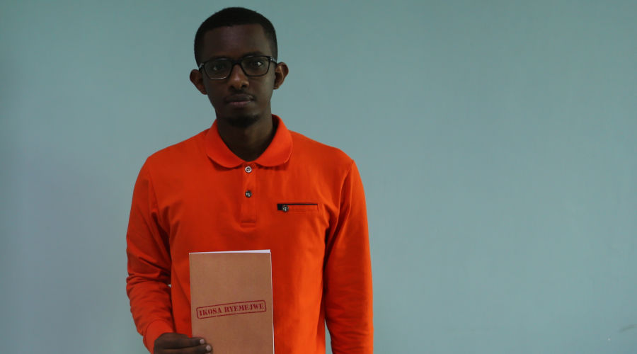 Honore Busoro with his book at The New Times offices. / Craish Bahizi