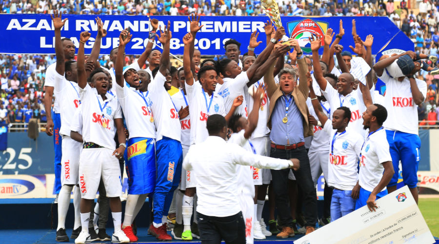 Rayon Sports players and coaching staff celebrate with the trophy and Rwf25 million dummy cheque after beating Marines 3-0 at Amahoro Stadium on Saturday. / Sam Ngendahimana