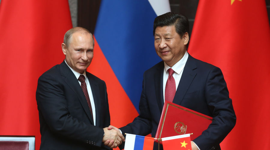 Xi Jinping and Vladimir Putin shake hands. The booming China-Russia relationship is also bringing the two countries closer. / Net