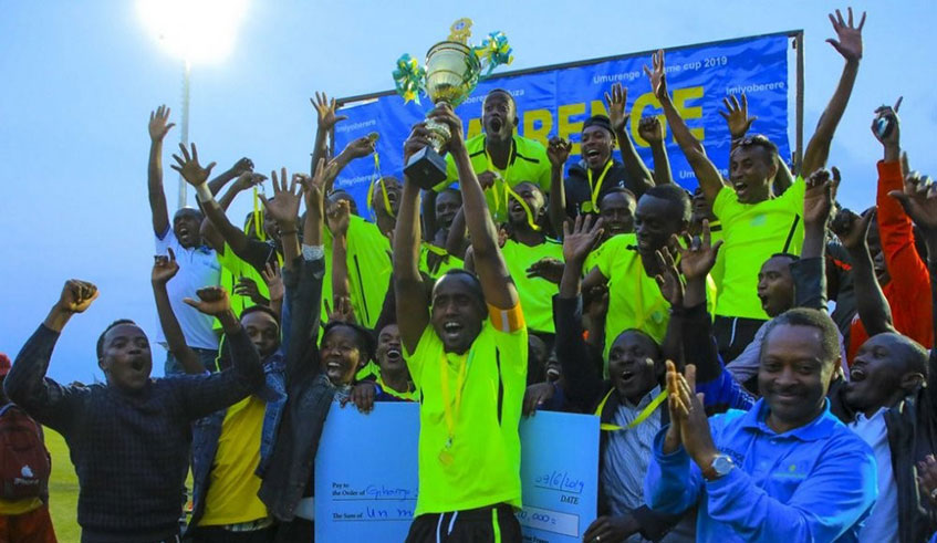 Gihango Sector players, carry the trophy aloft in wild celebrations after receiving it from Local Government Minister, Prof. Anastase Shyaka (right) at Huye Stadium on Sunday. Courtesy.