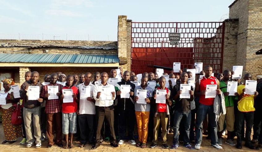 Some of the convicts hold certificates of release outside Muhanga Prison after being released on parole over the weekend. Courtesy.