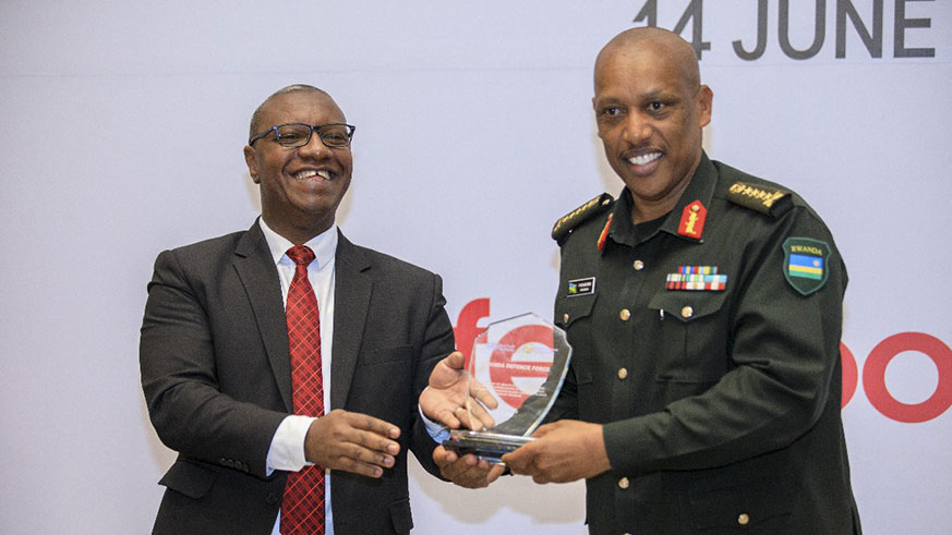 Gen. Nyamvumba (right) receives the award from Dr Patrick Ndimubanzi, the State Minister in charge of Public Health and Primary Health Care in Kigali yesterday. Courtesy.
