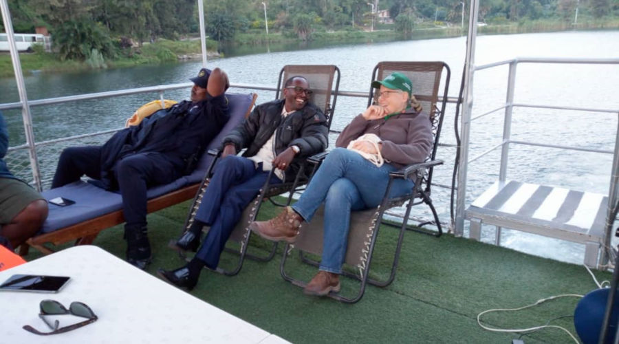 Western Province Governor Alphonse Munyentwari (C) chats with a tourist on a trip to Lake Kivu, Karongi District. / Ru00e9gis Umurengezi