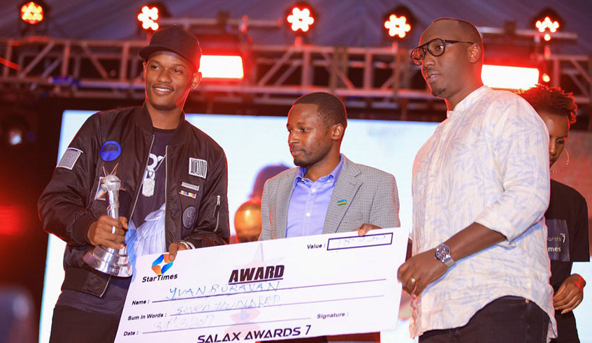 Buravan(left) and his manger Jean Marie Mukasa (right) pose with a dummy cheque which the artiste won in the Salax Awards this year. Courtesy photos.