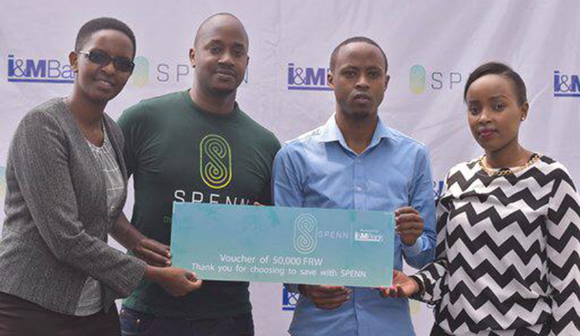 Left to right, Alice Kirezi, a Spenn official together with I&M Bank's Head of Marketing handing over the dummy voucher worth Rwf50,000 to James Nkontanyi in a blue shirt.All photos by Peter Nkurunziza.