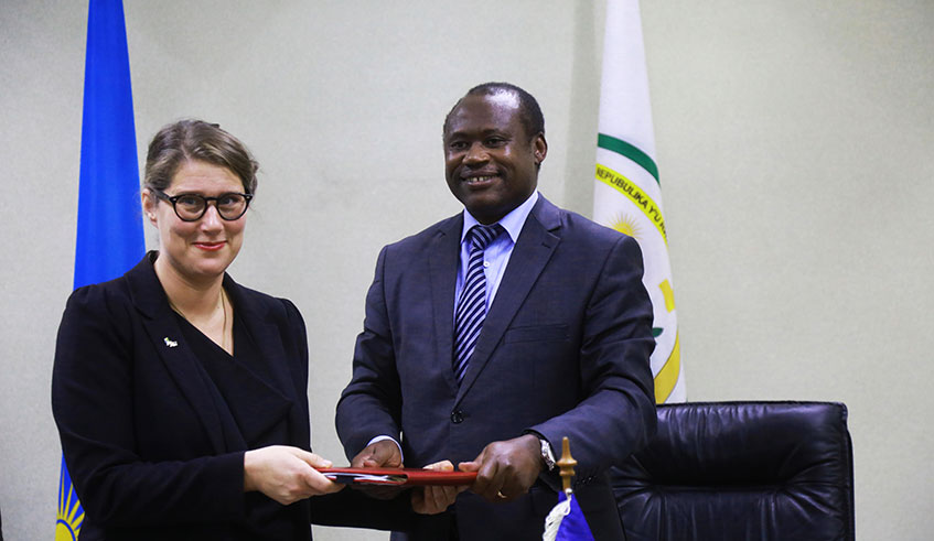 The Minister for Finance and Economic planning Uzziel Ndagijimana (right) and Amb. Jenny Ohlsson, the Swedish envoy to Rwanda, exchange documents after signing the  agreement in Kigali yesterday. Sam Ngendahimana.