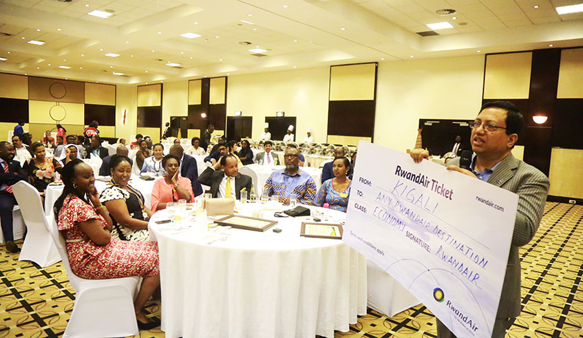 Members of Rotary Club Kigali-Virunga listen to Jwala Kumar as he leads the auction of a RwandAir ticket during a fundraising event for the construction of a transit accommodation facility for cancer patients in Rwanda, at Kigali Serena Hotel yesterday. Sam Ngendahimana.