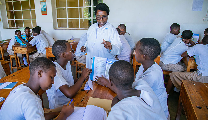Students of Institut Sainte Famille de Nyamasheke in classroom with their female teacher. Emmanuel Kwizera.