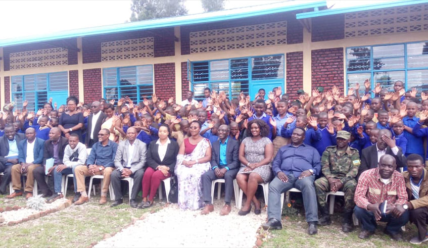 Members ofu00a0 Rwandan Diaspora in Germany, officials and students of GS Rwinzovu pose for a group photo in front of the classrooms. Ru00e9gis Umurengezi