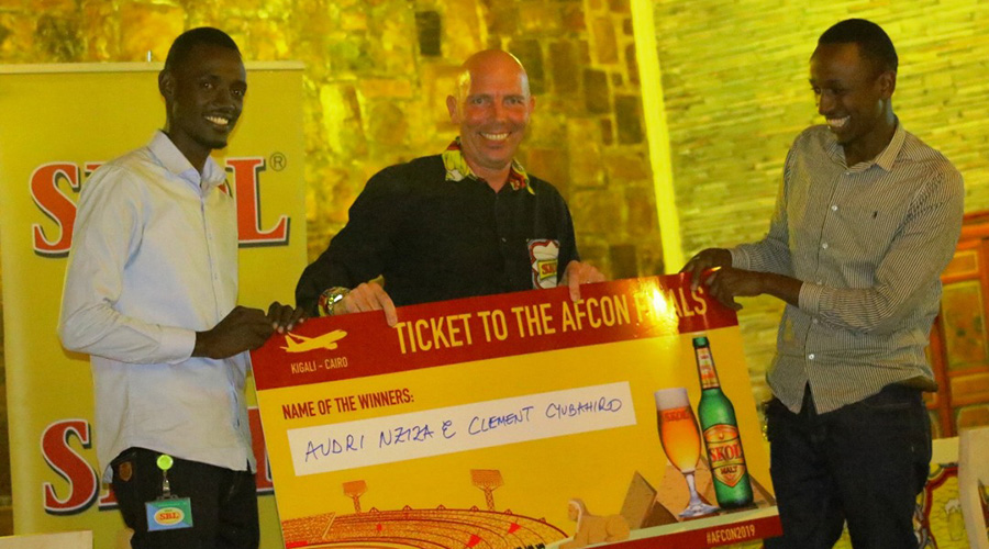 SKOL Brewery Commercial Director Evert G. Boersma(C) hands over the flight tickets to Nziza (L) and Cyubahiro (R) to watch the AFCON 2019 final live at Cairo International Stadium, Egypt. / Eddie Nsabimana