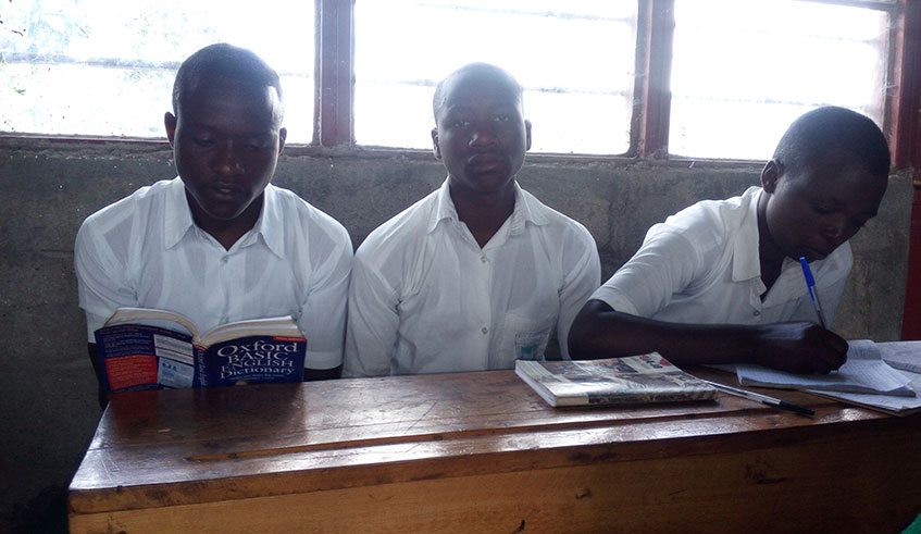 Silvestre Munyaneza (L) consults an English language dictionary in class. He said that after he quit consumption of illicit drug  his level of performance in class increased  significantly. Ru00e9gis Umurengezi.