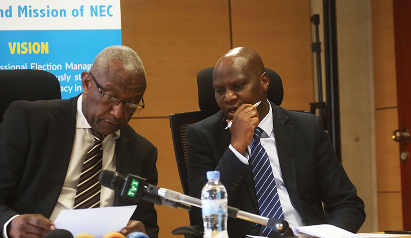The National Electoral Commissionu2019s chairperson Prof. Kalisa Mbanda (left) consults with Charles Munyaneza, the Commissionu2019s Executive Secretary during a news briefing yesterday. Sam Ngendahimana.