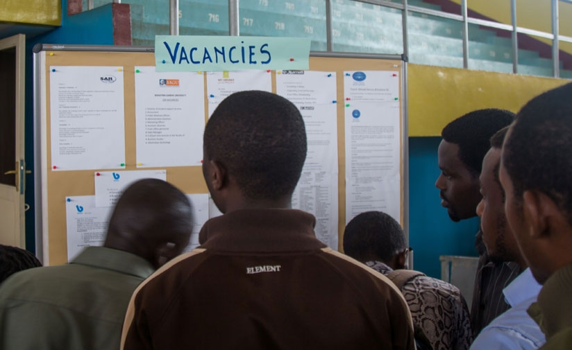 Job seekers read vacancy announcements on a notice board. Labour minister Rwanyindo told senators that some 214,000 jobs in the country are created every year. / Net photo