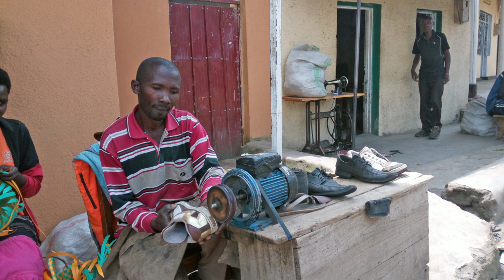 Niragire mends shoes at his workplace from Cyanika Centre in Burera District. / Ru00e9gis Umurengezi