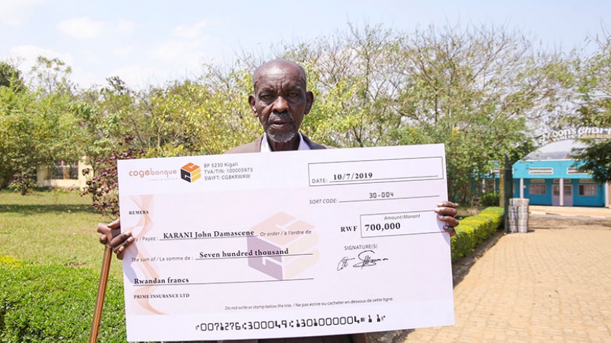 Jean Damascene Karani shows off the dummy cheque for the Rwf700,000 compensation for his dead cow in Nyagatare District, Eastern Province, Friday, July 19, 2019. / Courtesy
