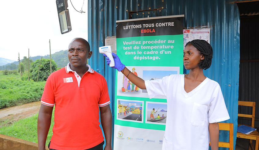 A health work uses a thermometer to test for possible Ebola symptoms on passengers from Uganda to Rwanda at Gatuna Border in May 27, 2019. Emmanuel Kwizera.