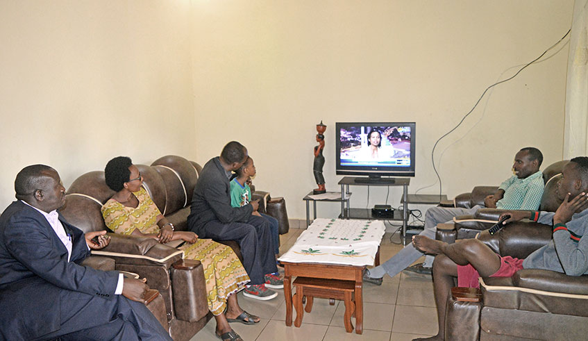 Vistors watching TV at Mulindahabi's home.