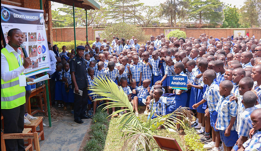 Police officers and trainers in driving schools explaining the meaning of traffic signs to pupils of St Dominique savio Remera in Gasabo District. Courtesy.