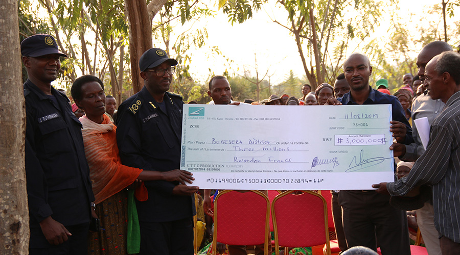 ACP Cu00e9lestin Twahirwa hands over a dummy cheque for medical insurance cover to local authorities in Bugesera District. / Courtesy