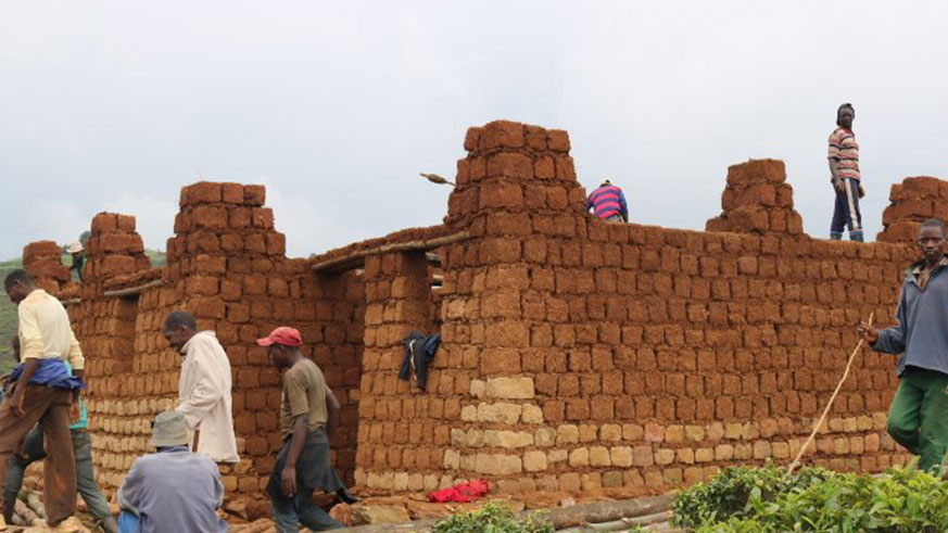 Workers building mud brick walls at house construction site in Rwanda. Net photo.