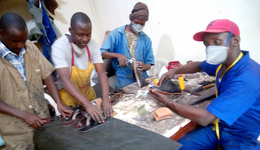 Mvugiki and his employees busy in their workshop . Simon Peter Kaliisa