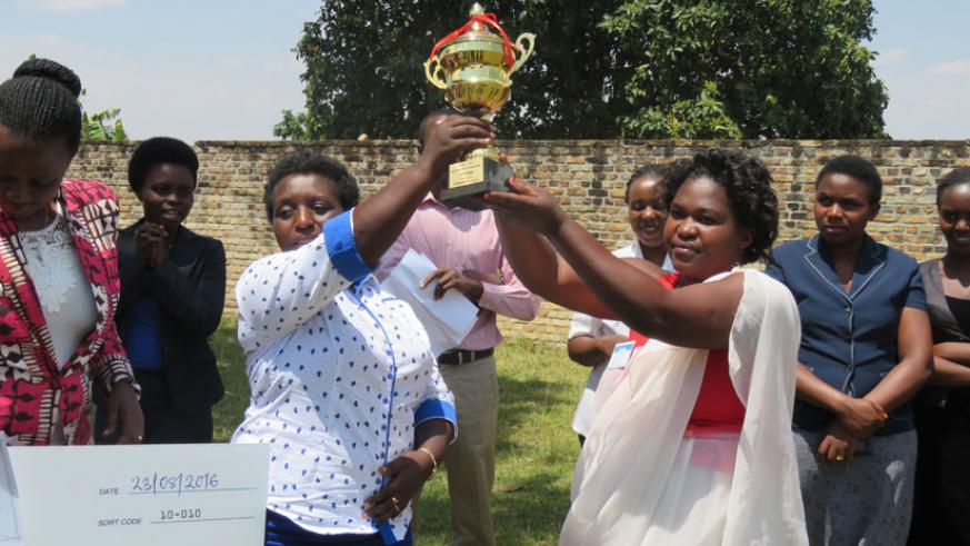 Mayor Uwamariya (L) hands over a trophy to the best performing cooperative at a past event. Uwamariya has been Muhanga Mayor for the last four years. 