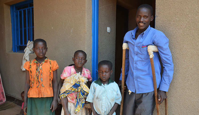 Former Sharita Island resident Antoine Mukeshimana poses with his children at his new house at Rweru model village in Bugesera.