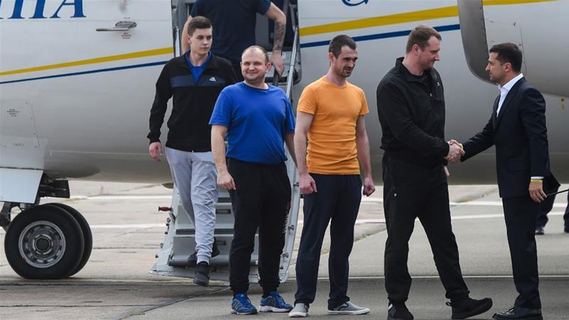 Ukraine's President Volodymyr Zelensky welcomes former prisoners as there arrive in Kiev. / AFP