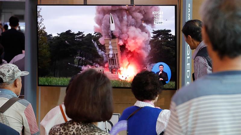 People in South Korea watch TV news reports showing file pictures on North Korea's latest missile launch. / AFP