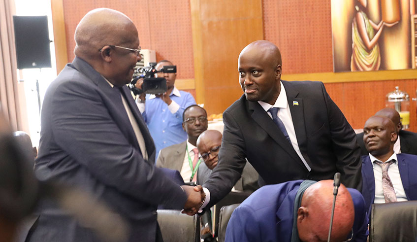 Amb. Olivier Nduhungirehe, Rwanda's Minister of State in charge of the East African Community (right), shakes hands with Ugandan Foreign Affairs minister Sam Kuteesa during the first meeting of the ad hoc commission on the implementation of the Luanda MoU between Rwanda and Uganda in Kigali yesterday. Emmanuel Kwizera.